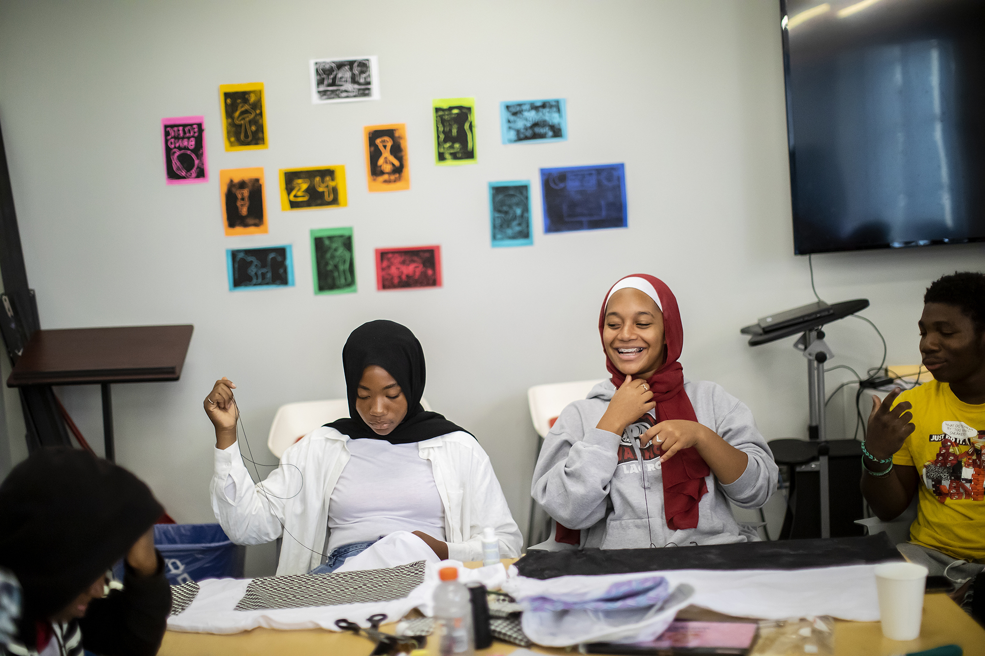Penn Praxis Photo of students sewing with fabric in front of them