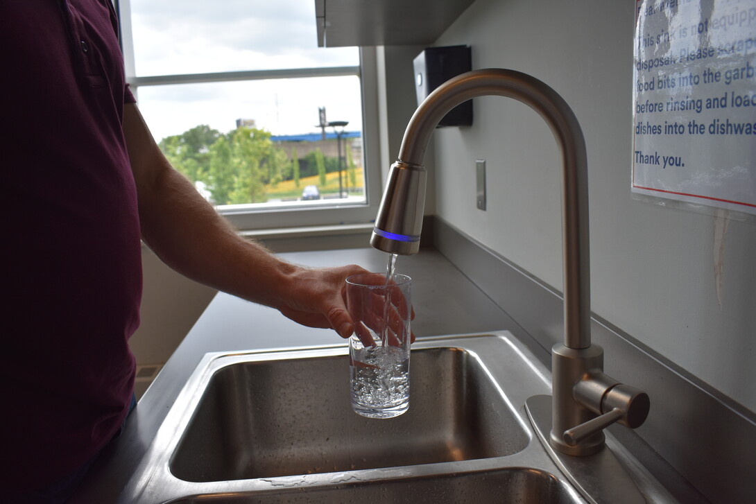 Man getting water from faucet